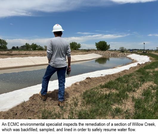 An ECMC inspector views a lined creek channel